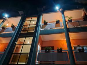 杜阿拉的住宿－Residence New Standing Douala CITE CHIRAC YASSA，一座公寓楼,晚上在阳台上种有盆栽植物
