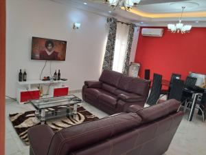 uma sala de estar com um sofá e uma mesa em Residence New Standing Douala CITE CHIRAC YASSA em Douala