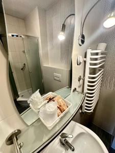 オストルフ・ビエルコポルスキにあるHotel Pod Dębamiのバスルーム(洗面台、鏡付)