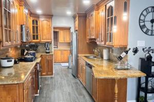 a kitchen with wooden cabinets and granite counter tops at King Bed, 3 miles to Stadium in Miami Gardens