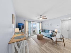 ein Wohnzimmer mit einem Tisch und einem blauen Sofa in der Unterkunft The Sea Willow - Beautiful ocean views! 2nd Floor - Oceanfront! condo in Carolina Beach