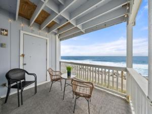 einen Balkon mit einem Tisch, Stühlen und Meerblick in der Unterkunft The Sea Willow - Beautiful ocean views! 2nd Floor - Oceanfront! condo in Carolina Beach