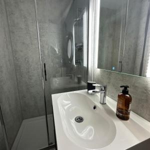a bathroom with a white sink and a shower at La Mare Resort in Gothenburg