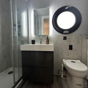 a bathroom with a sink and a toilet and a mirror at La Mare Resort in Gothenburg