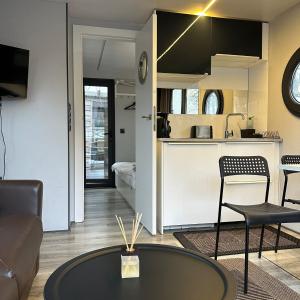 a living room with a table and a kitchen at La Mare Resort in Gothenburg