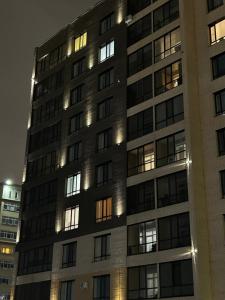 a tall building with many windows at night at NURAS-APART in Kirovo
