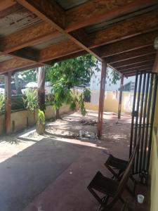 a patio with a chair under a wooden roof at Studios Léa in Nosy Be