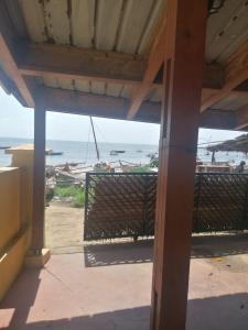 a view of the ocean from a porch with a fence at Studios Léa in Nosy Be