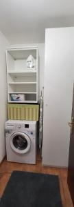 una lavatrice e un'asciugatrice in una stanza accanto a una porta di Alfa Appartamento in centro a Gorizia