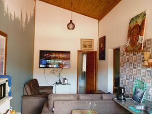 a living room with a couch and a tv at hospedagem Manaká proximo ao Centro vista incrível in Cunha