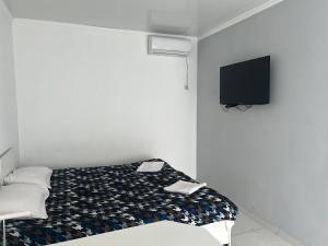 um quarto com uma cama e uma televisão na parede em Отель Рублёвка em Kant