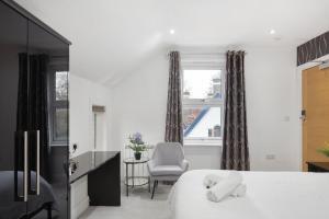 a bedroom with a bed and a chair and a window at Modern city centre studio apartment! in Oxford