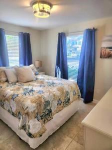 1 dormitorio con 1 cama con cortinas azules en The Gardenia House, en Naples