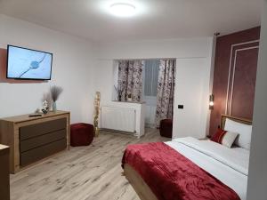 a bedroom with a bed and a tv on the wall at Central Train Station Apartment in Braşov