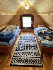 a bedroom with two beds in a wooden cabin at Bajkowa dolina in Niegowa