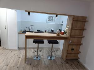 a kitchen with a counter with two stools at a table at Central Train Station Apartment in Braşov +19 photos