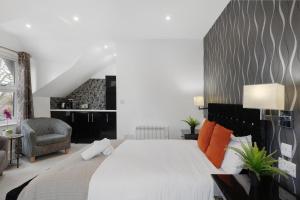 a bedroom with a large white bed with orange pillows at Modern city centre studio apartment in Oxford