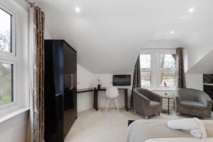 a bedroom with a bed and a desk and a tv at Modern city centre studio apartment in Oxford