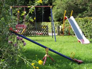 a swing set and a playground in a yard at Gasthof und Metzgerei zur Post Peißenberg in Peißenberg