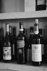 cuatro botellas de vino sentadas en un estante en Dimora Valverde B&B, en Marano di Valpolicella