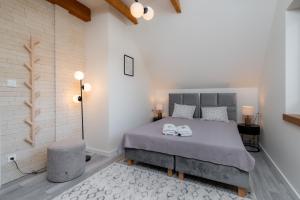 um quarto com uma cama com duas toalhas brancas em Domki Kamieniec 