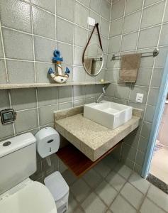 uma casa de banho com um lavatório, um WC e um espelho. em Flat Cumaru ap 210 TEMPORADANOFRANCES Localização privilegiada e conforto na Praia do Francês