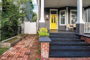 a house with a yellow door and stairs at Historic 3 Bedroom Home in Jacksonville