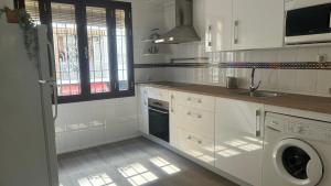 Una cocina blanca con fregadero y lavavajillas. en Selecta Casa junto a Triana, en Sevilla 7 fotos más