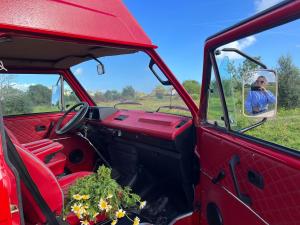 un hombre tomando una foto en el espejo de un camión rojo en Rent a Blue Classics' s Campervan for your Road trip in Portimao -VOLKSWAGEN T3 en Portimão