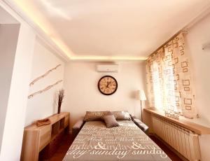 a bedroom with a bed and a clock on the wall at IL DANDY appartamento con parcheggio in Trieste