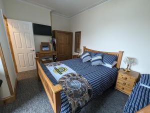 een slaapkamer met een bed met een blauw gestreept dekbed bij Jurassic Bay Holidays in Weymouth
