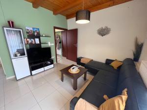 a living room with a blue couch and a tv at House Hévíz in Hévíz