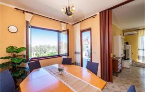 a dining room with a wooden table and a large window at Apartment Serda in Ugljan