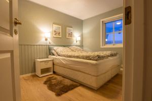a small bedroom with a bed and a window at Lovely house in Tromso in Tromsø