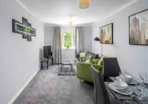 uma sala de estar com um sofá verde e uma mesa em Crawley Thornhill 1 Bed Apartment near Gatwick Airport with Free Parking em Ifield