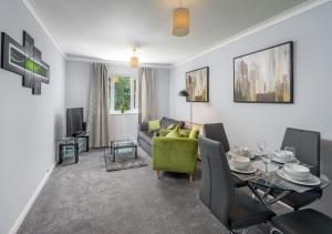 een woonkamer met een groene bank en een tafel bij Crawley Thornhill 1 Bed Apartment near Gatwick Airport with Free Parking in Ifield