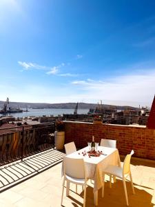 een tafel en stoelen op een balkon met uitzicht bij IL DANDY appartamento con parcheggio in Trieste