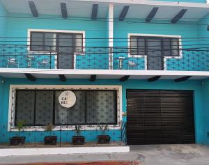 um edifício azul com uma porta e uma varanda em Casa Kuxul em Mérida