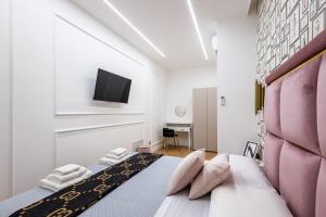 a bedroom with a bed with a pink headboard at Maison 31 -Luxury Apartments in Santa Marinella