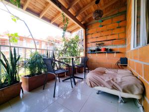 Un balcón con una cama, sillas y una mesa. en Casa cómoda en Rionegro Antioquia, en Rionegro