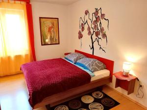 a bedroom with a red bed with a flower mural on the wall at Gasthof Zemlinski Family Room in Payerbach