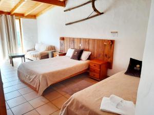 a bedroom with two beds and a couch and a chair at Quinta Pedagógica da Samoqueirinha - Duna Parque Group in Vila Nova de Milfontes