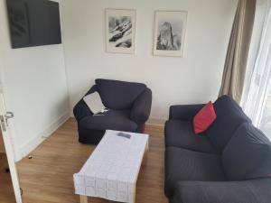 a living room with two chairs and a table at 2 double bedrooms apartment near airport & town in Dublin