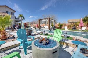 eine Terrasse mit Stühlen und einer Feuerstelle neben einem Pool in der Unterkunft Luxurious Henderson Retreat - 13 Mi to The Strip! in Las Vegas