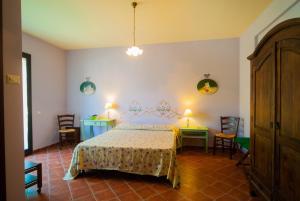 a bedroom with a bed and two tables and chairs at B&B La Rena Rossa in Nicolosi