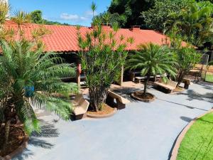 a courtyard with palm trees and a building with a red roof at Ecologic Park, apt 2 quartos 900 mt do centro de Caldas Novas in Caldas Novas