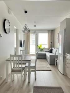 uma cozinha e sala de estar com mesa e cadeiras em Kotimaailma Apartments Tervapääsky I em Oulu