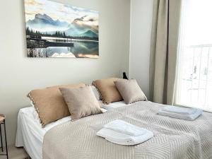 a bedroom with a bed with two towels on it at Kotimaailma Apartments Tervapääsky I in Oulu