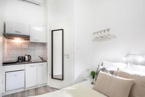 a white room with a bed and a mirror at Very Central - Small Studio for Solo Traveller in Budapest