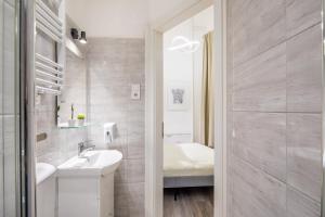 a white bathroom with a sink and a mirror at Very Central - Small Studio for Solo Traveller in Budapest